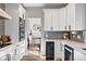 Modern kitchen with stainless steel appliances, white cabinets, and a view into the dining room, making it perfect for entertaining at 1053 Snow Lily Ct, Castle Pines, CO 80108