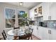 Cozy kitchen nook with a glass table, surrounded by a view of the trees outside at 1053 Snow Lily Ct, Castle Pines, CO 80108