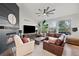 Cozy living room featuring a fireplace, leather sofa, and views of the outdoors at 1053 Snow Lily Ct, Castle Pines, CO 80108