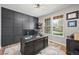 Stylish office space with a large desk, a custom feature wall, and ample natural light from the windows at 1053 Snow Lily Ct, Castle Pines, CO 80108