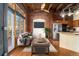 Bright living room features exposed brick walls, hardwood floors, and large windows at 2960 Inca St # 308, Denver, CO 80202