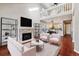 Open concept living room with fireplace, second story loft, and views into the kitchen at 7765 S Curtice Dr # A, Littleton, CO 80120