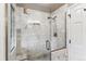 Luxurious shower features white marble tile surround and glass door at 7765 S Curtice Dr # A, Littleton, CO 80120