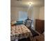 Bedroom with comfortable bed, treadmill, dresser, and natural light from the window, perfect for relaxation at 1132 Moline St, Aurora, CO 80010