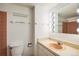 Bathroom featuring white walls, a peach colored sink and accents, a mirror with lightbulbs, and a toilet at 850 20Th St # 203, Boulder, CO 80302