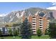 Scenic view of a brick apartment building nestled beneath a majestic mountain range, offering a serene living environment at 850 20Th St # 203, Boulder, CO 80302