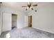Carpeted bedroom with a ceiling fan, closet, and view to another room at 5537 Lewis Ct # 4, Arvada, CO 80002