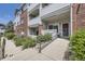 Ground floor condo entrance with small bushes and gray metal railing and a red front door at 5537 Lewis Ct # 4, Arvada, CO 80002