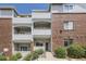 Multi-level condo building with brick and siding and multiple balconies and a red front door at 5537 Lewis Ct # 4, Arvada, CO 80002