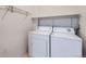 Bright laundry room featuring a white washer and dryer set with shelving for extra storage at 5537 Lewis Ct # 4, Arvada, CO 80002