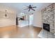 Open living space with wood floors, stone fireplace and ceiling fan open to kitchen at 5537 Lewis Ct # 4, Arvada, CO 80002
