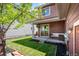 A tranquil backyard featuring a lush lawn, patio seating, and mature tree canopy at 9007 E 60Th Ave, Denver, CO 80238