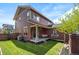 A lovely backyard with a well-maintained lawn, covered patio, and beautiful landscaping at 9007 E 60Th Ave, Denver, CO 80238