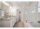 Bright bathroom with double vanity, soaking tub, and glass enclosed shower at 9007 E 60Th Ave, Denver, CO 80238