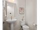 Powder bathroom boasts a pedestal sink, framed mirror, modern fixtures, and contemporary décor at 9007 E 60Th Ave, Denver, CO 80238