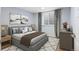 A calming bedroom featuring a queen bed, soft blue walls, neutral decor, and ample natural light at 9007 E 60Th Ave, Denver, CO 80238