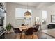 Bright dining room features modern lighting, hardwood floors, and a round dining table with seating for four at 9007 E 60Th Ave, Denver, CO 80238