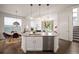 Stylish kitchen island with stainless steel dishwasher and a view into an adjacent dining and living area at 9007 E 60Th Ave, Denver, CO 80238