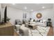 Comfortable living room featuring a modern sofa, stylish chairs, and decorative mirror over an area rug at 9007 E 60Th Ave, Denver, CO 80238