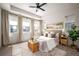 Airy main bedroom offers a tray ceiling, neutral tones, bedside tables, and a cozy sitting area at 9007 E 60Th Ave, Denver, CO 80238