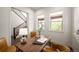 Home office features a wooden desk, neutral color scheme, and plenty of natural light from the two windows at 9007 E 60Th Ave, Denver, CO 80238