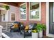 Inviting covered porch with stylish seating, decorative pillows, and potted plants for a cozy outdoor space at 9007 E 60Th Ave, Denver, CO 80238