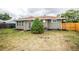 Exterior view of the back of the house, backyard with a tall evergreen and a partial fence at 740 Moline St, Aurora, CO 80010