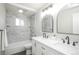 Modern bathroom featuring dual sinks, tiled walls and flooring, and neutral paint at 740 Moline St, Aurora, CO 80010