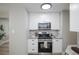 Kitchen featuring stainless steel appliances, gray backsplash, and white cabinetry at 740 Moline St, Aurora, CO 80010