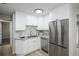 Modern kitchen featuring stainless steel appliances, gray backsplash, and white cabinetry at 740 Moline St, Aurora, CO 80010