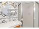 Bathroom featuring decorative accent wall, round mirror and shower with sliding glass door at 1226 Clayton St, Denver, CO 80206