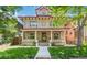 Charming two-story home with a welcoming front porch and well-manicured lawn at 1226 Clayton St, Denver, CO 80206