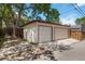 Two-car detached garage with concrete driveway with mature trees and fencing at 1226 Clayton St, Denver, CO 80206