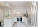Traditional kitchen features white cabinets, stainless steel appliances, and a breakfast bar area at 1226 Clayton St, Denver, CO 80206