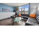 Cozy living room with large windows, a modern black leather sofa, and a stylish glass coffee table at 2539 Lawrence St, Denver, CO 80205