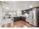 Basement kitchen features stainless steel appliances, dark wood cabinets, and hardwood floors at 5077 W 108Th Cir, Westminster, CO 80031