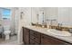 Bathroom with double sink vanity, granite countertops, decorative mirror, and modern fixtures at 5077 W 108Th Cir, Westminster, CO 80031