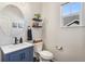 Bathroom featuring a navy vanity, round mirror, floating shelves, and natural light at 5077 W 108Th Cir, Westminster, CO 80031