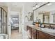 Bright bathroom featuring granite counters, double sinks, and an open doorway to the main bedroom at 5077 W 108Th Cir, Westminster, CO 80031