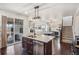 Kitchen with island open to living space, featuring stainless steel appliances and dark hardwood floors at 5077 W 108Th Cir, Westminster, CO 80031