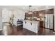 Open-concept kitchen with an island, pendant lighting, stainless steel refrigerator, and dark hardwood floors at 5077 W 108Th Cir, Westminster, CO 80031