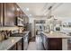 An open kitchen with granite countertops, stainless steel appliances, dark wood cabinets, and hardwood floors at 5077 W 108Th Cir, Westminster, CO 80031