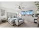Sun-filled main bedroom featuring plush carpet, ceiling fan, sitting bench, and a scenic view from multiple windows at 5077 W 108Th Cir, Westminster, CO 80031