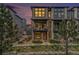 Modern townhouse featuring a private balcony, stone accents, and large windows for ample natural light in the evening sky at 522 Meridian Ln, Superior, CO 80027