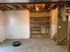 Unfinished basement with a carpeted floor and built-in wooden shelving at 3824 S Quemoy Way, Aurora, CO 80018