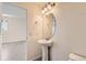 Stylish half bathroom with pedestal sink, elegant mirror, and neutral decor, offering a convenient and well-appointed space at 4795 E 98Th Pl, Thornton, CO 80229