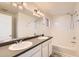 Bathroom featuring double sinks, a large mirror, and a shower-tub combo, providing a functional and well-lit space at 4795 E 98Th Pl, Thornton, CO 80229