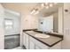 Bathroom featuring double sinks, a large mirror, and convenient access to the bedroom, creating a practical and stylish space at 4795 E 98Th Pl, Thornton, CO 80229