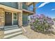 Inviting townhouse entrance with stone accents, a covered balcony, and vibrant landscaping, creating a welcoming curb appeal at 4795 E 98Th Pl, Thornton, CO 80229
