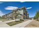 Exterior view of a townhouse with green siding, stone accents, and a private garage, showcasing its modern design at 4795 E 98Th Pl, Thornton, CO 80229